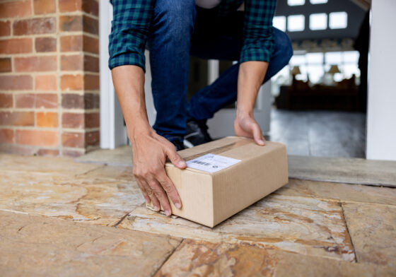 Person receiving a package on their doorstep.